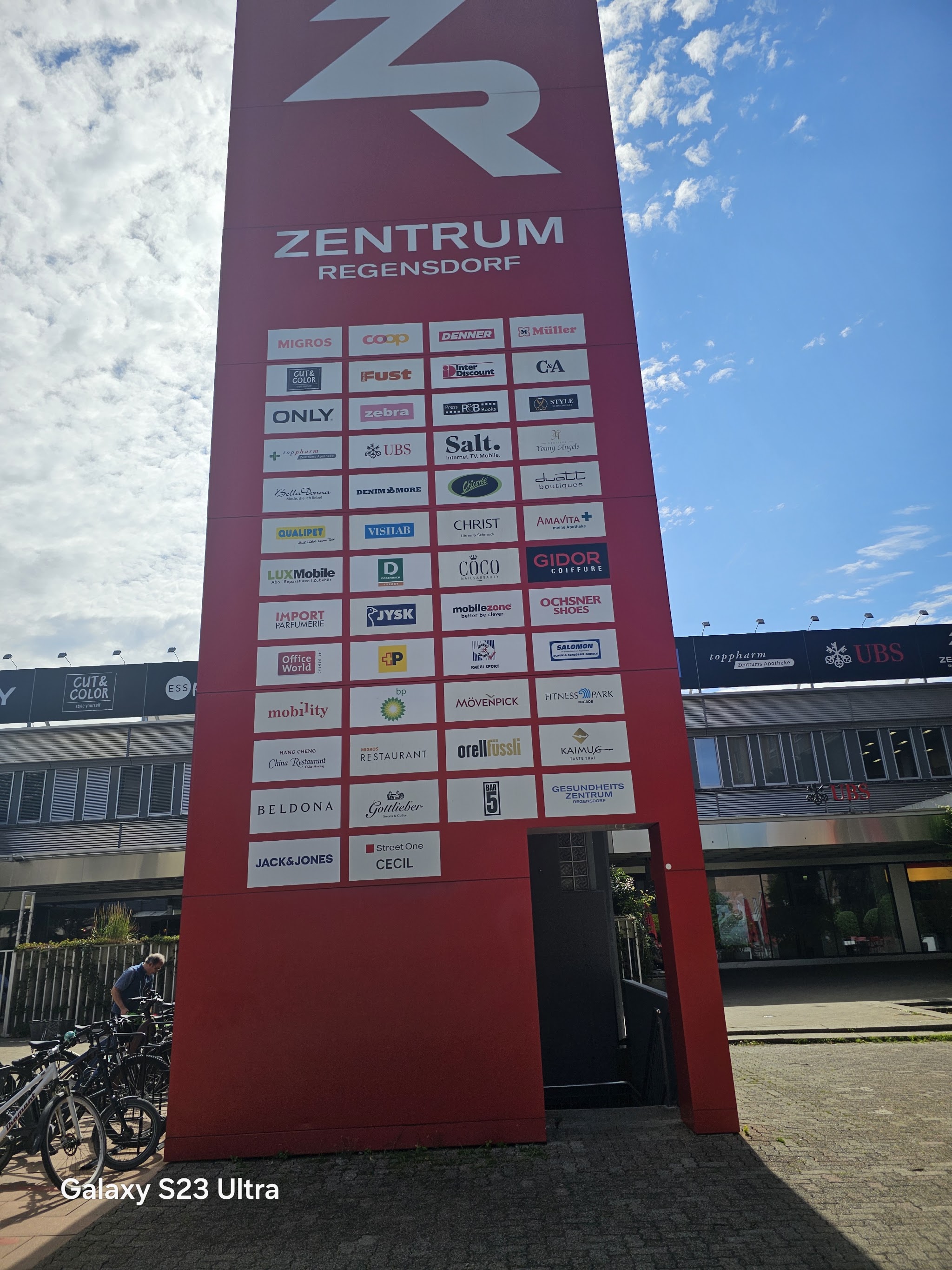 Roter Wegweiser des Zentrum Regensdorf mit den Schildern der Geschäfte